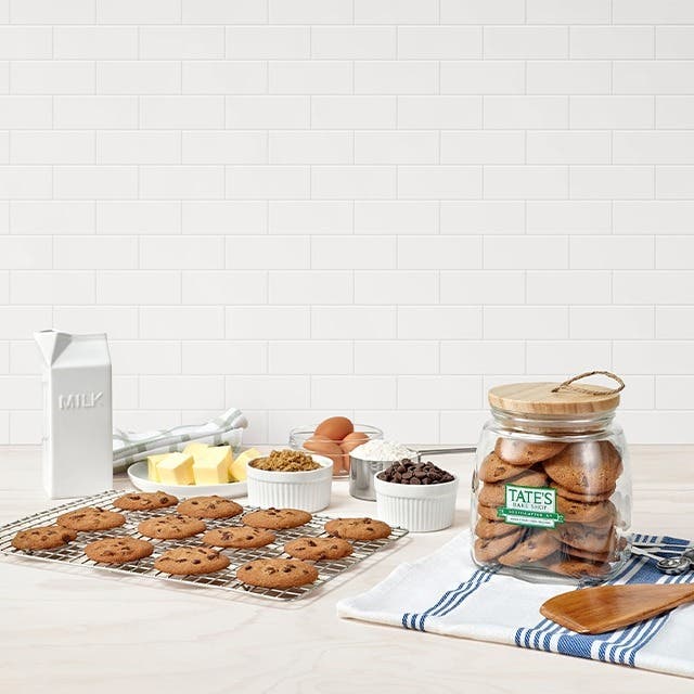 A bowl of chocolate chip cookies and bags of chocolate chip cookies on a table