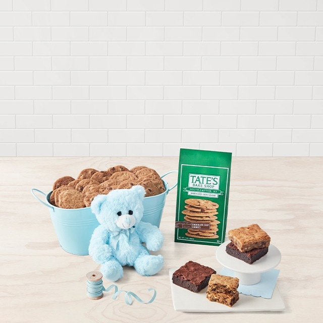 Various baked goods, cookies, a blue stuff bear and a children's book on a table